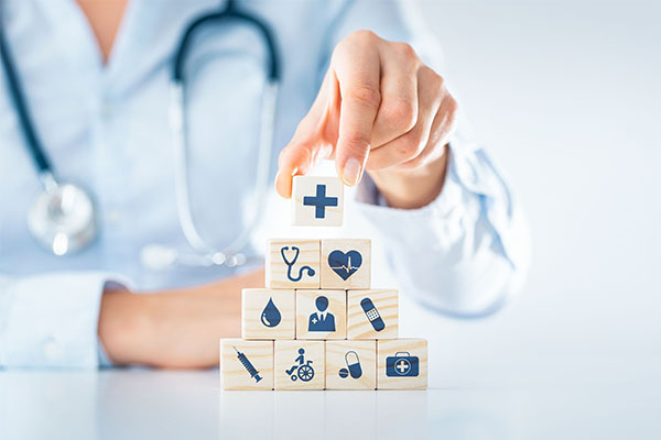 Doctor stacking blocks with healthcare symbols